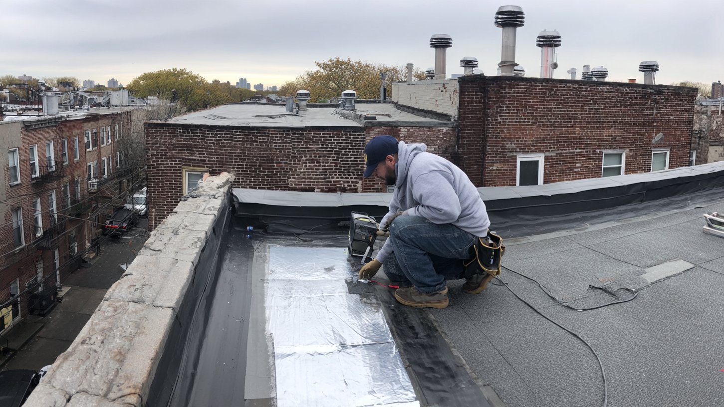 Commercial building in Brooklyn with a flat roof where BST Roofers is stopping an active leak