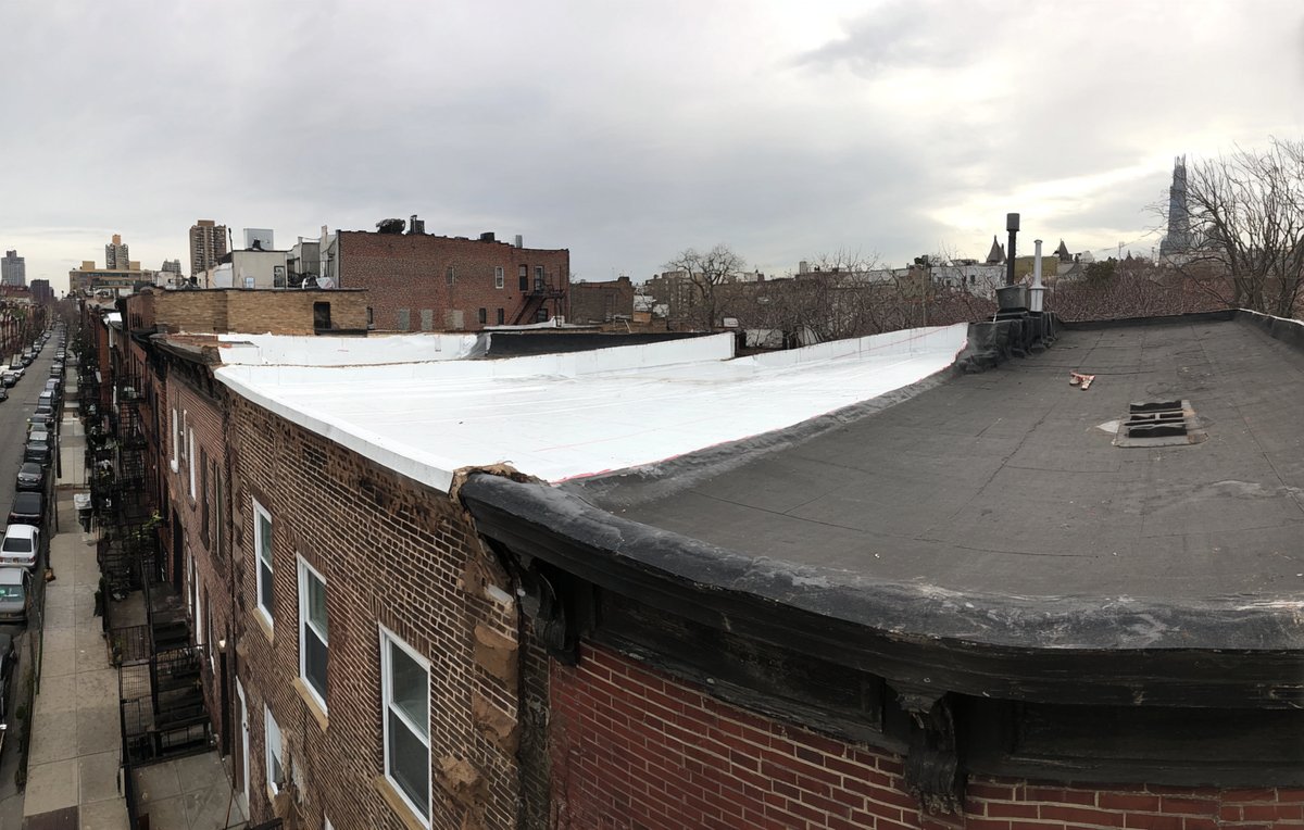 White TPO membrane next to black EPDM rubber on neighbouring Brooklyn row house roofs